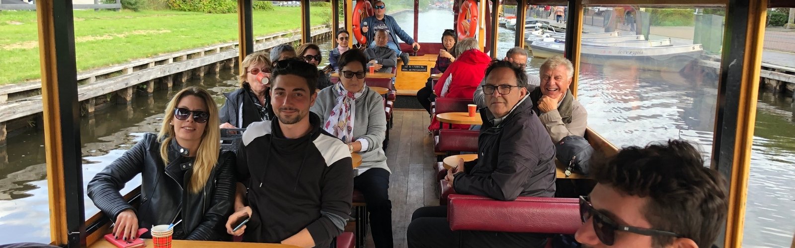 A group of people enjoys a canal cruise through Giethoorn.