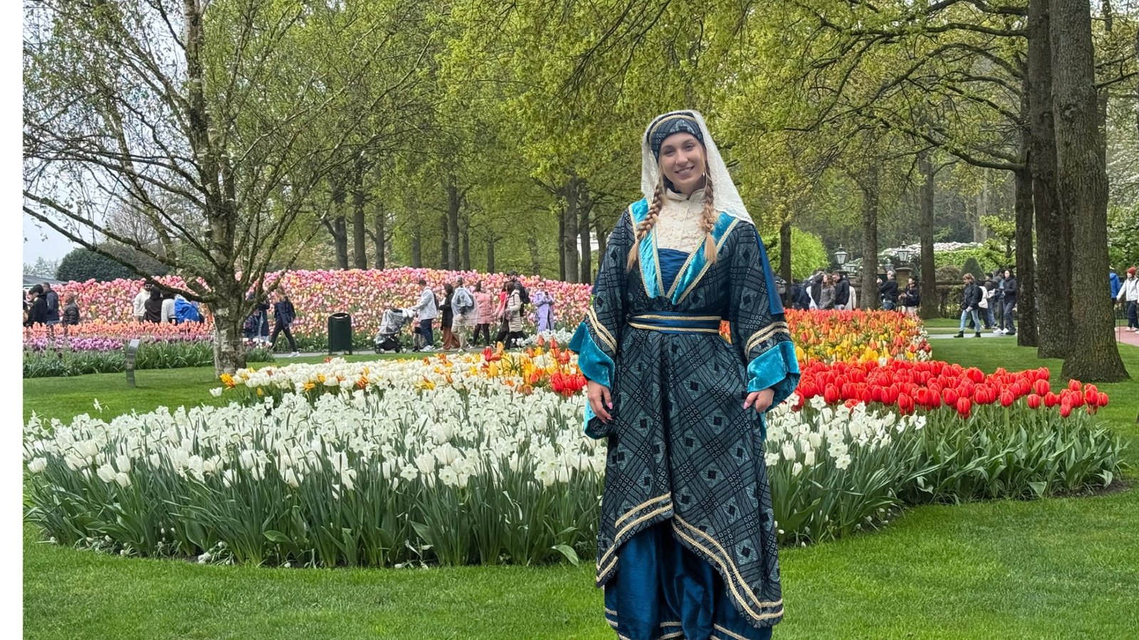 A lady in traditional attire among colorful tulips in Keukenhof Gardens
