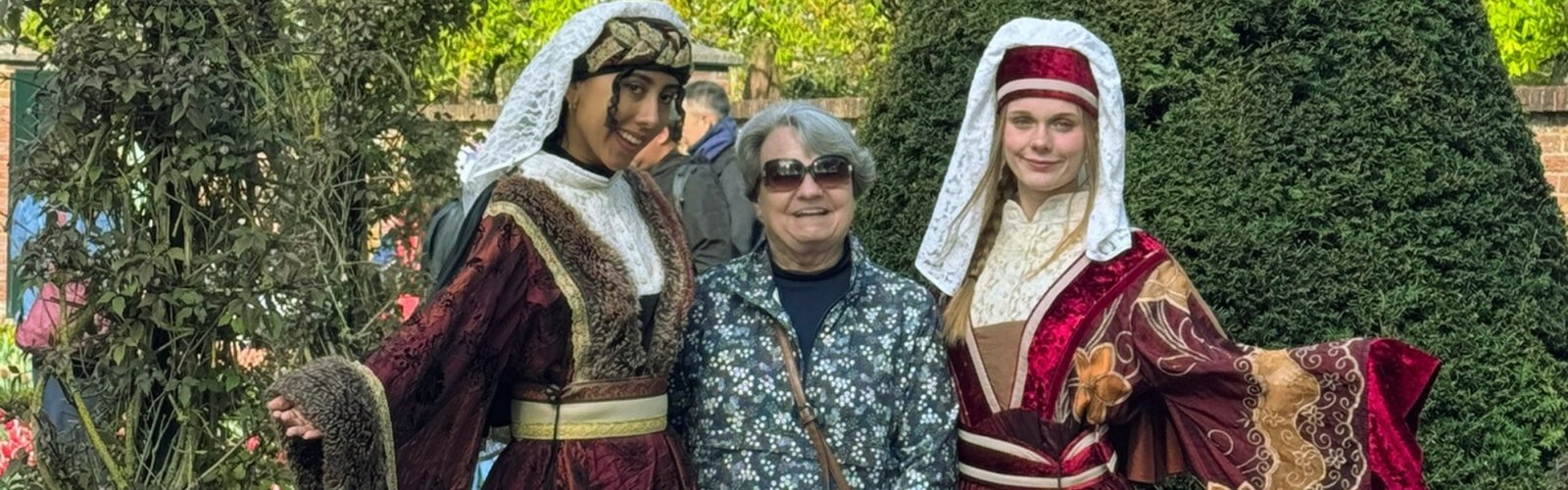 Three people enjoying outdoor garden in costumes
