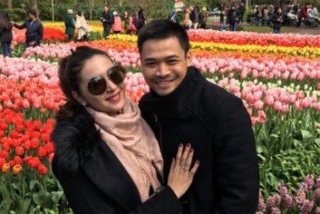 a man and woman posing for a picture in a field of flowers
