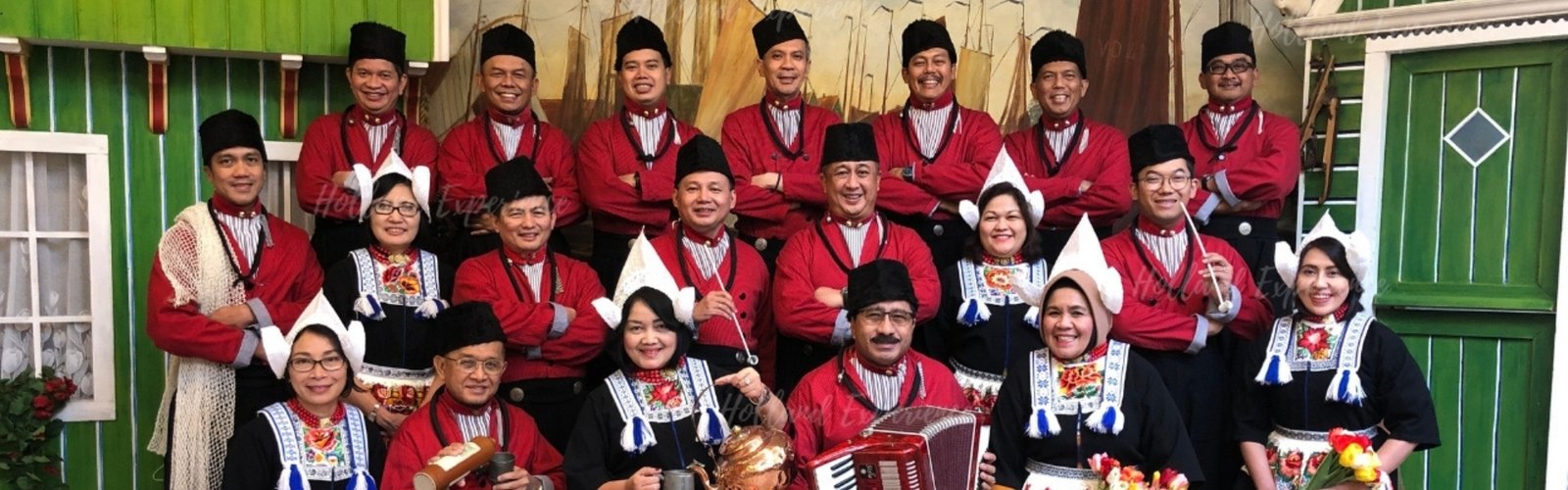 Group in traditional Dutch costumes posing indoors in Volendam