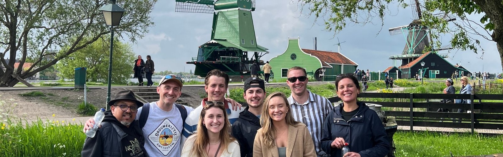 A group of tourists poses for a photo in front of the windmill at Zaanse Schans.