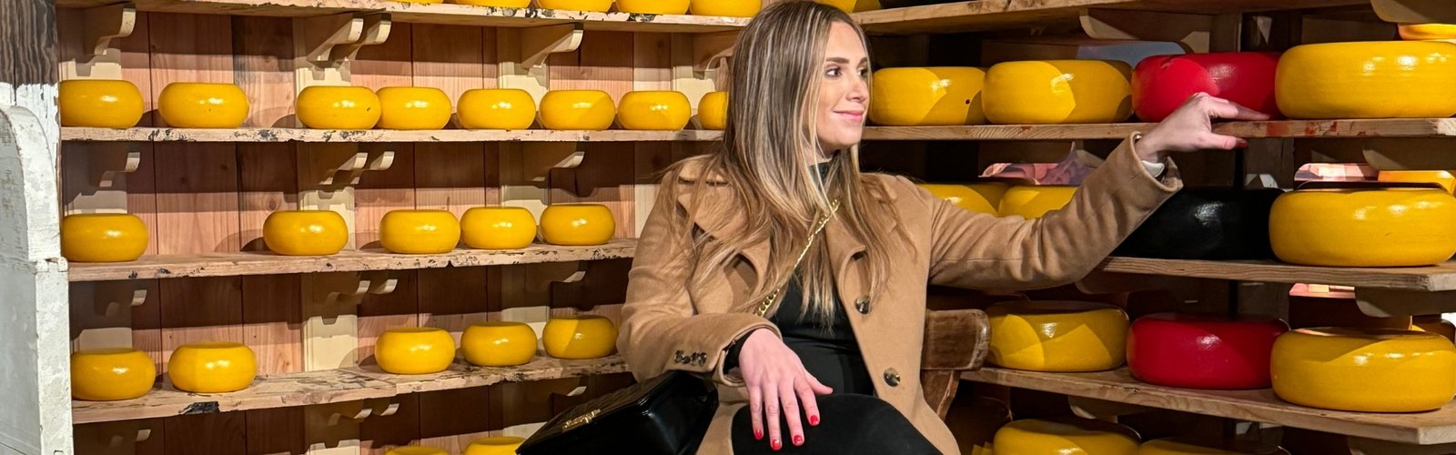 A beautiful woman poses in front of the cheese display at Zaanse Schans.